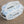 white and blue cosmetic bag on the beach. 