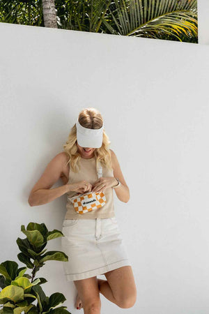 model holding white and orange bumbag over shoulder