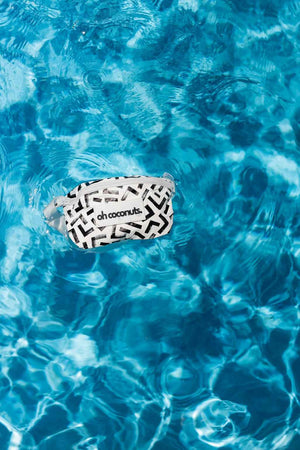 black and white bumbag floating in a bright blue pool