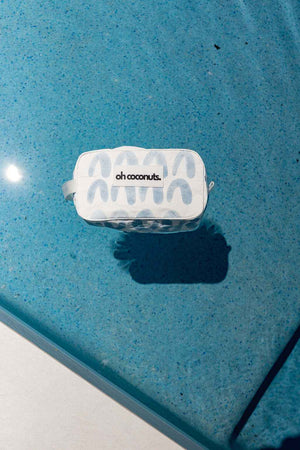 blue and white cosmetic bag floating in pool. 