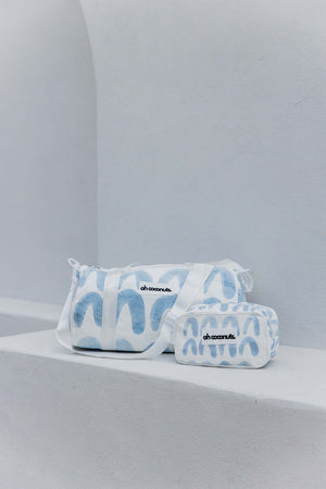 matching duffel bag and cosmetic bag sitting on white concrete