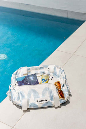 blue and white gym bag sitting by pool