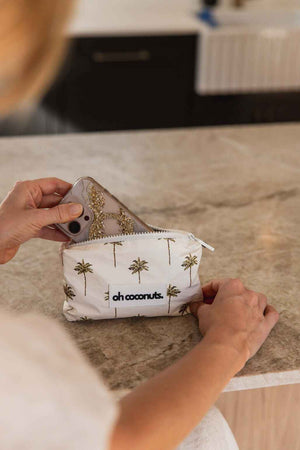 model holding oh coconuts pouch with sparkly iphone case 