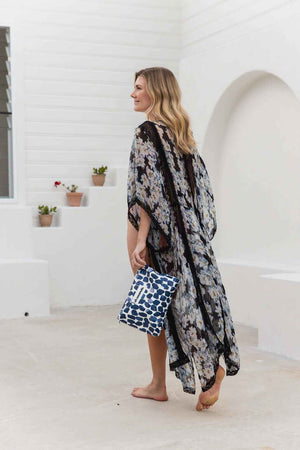 model in sarong holding dark blue oh coconuts pouch