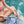 model in pink bikini sitting at pool with oh coconuts bag