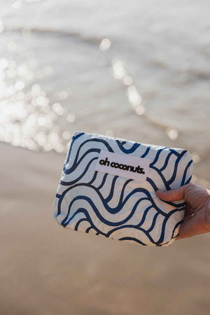 hand holding blue wet dry pouch on beach 