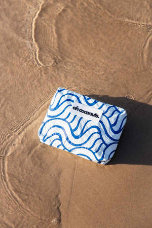 wet dry bag blue laying on the sand in water