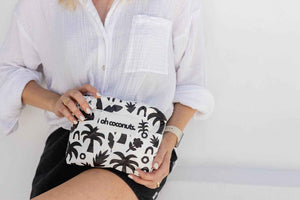model holding white and black palm tree pouch