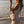 model on beach in white crochet dress holding pink oh coconuts bag