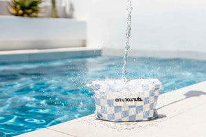 water spilling over blue and white checkered bag by pool